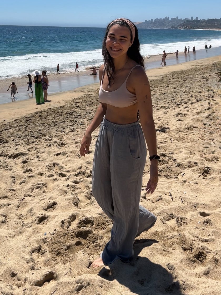 Agus Rogelja sonriendo en la playa, de pie sobre la arena